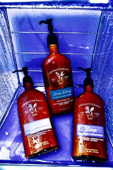 Three bottles of hair care products with pumps in shades of red and blue.